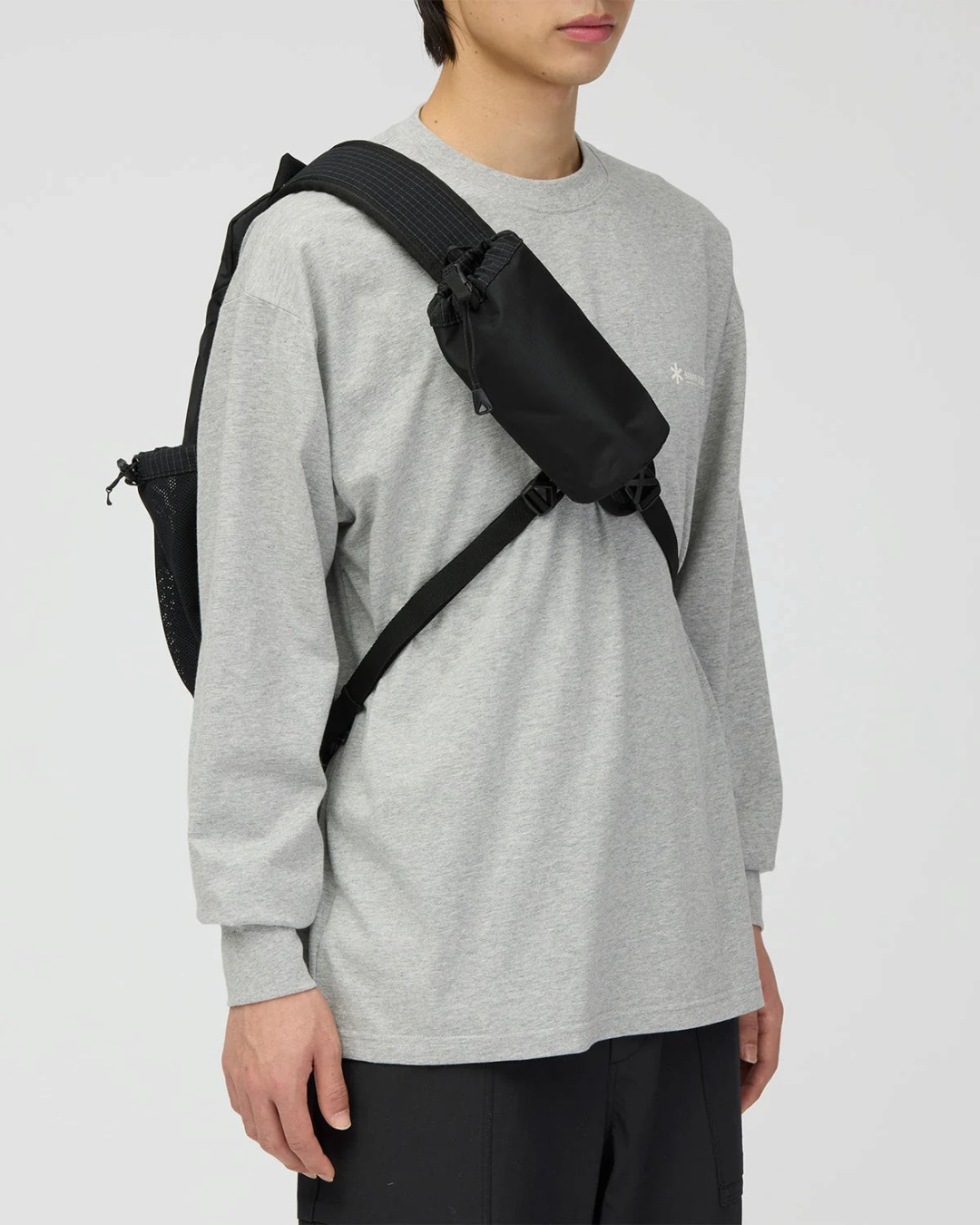 Sac bandoulière noir Merci Paris Snow Peak en tissu ripstop avec pochette amovible porté par un homme