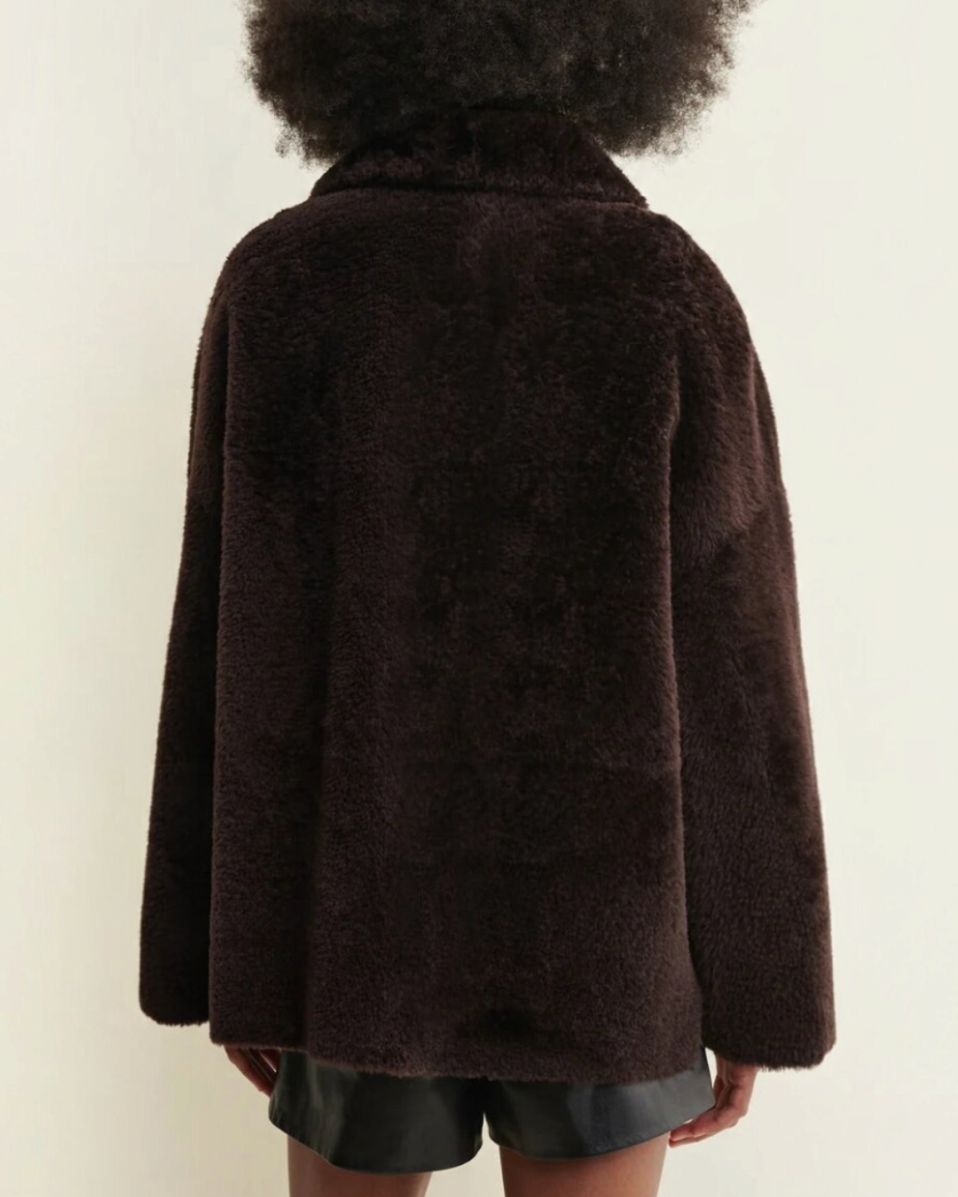 Manteau réversible Arma Isabella en shearling marron grain de café porté par une femme, vue de dos, chez Merci Paris