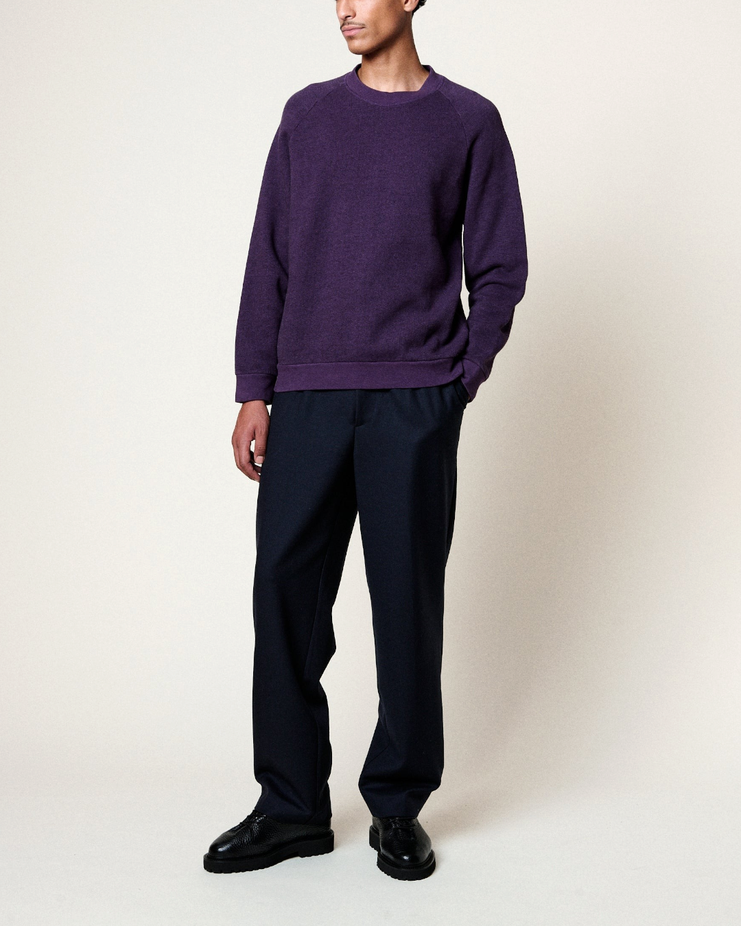 Homme portant le sweat Terry Merci Paris de couleur raisin avec manches raglan et bordures côtelées en diagonale