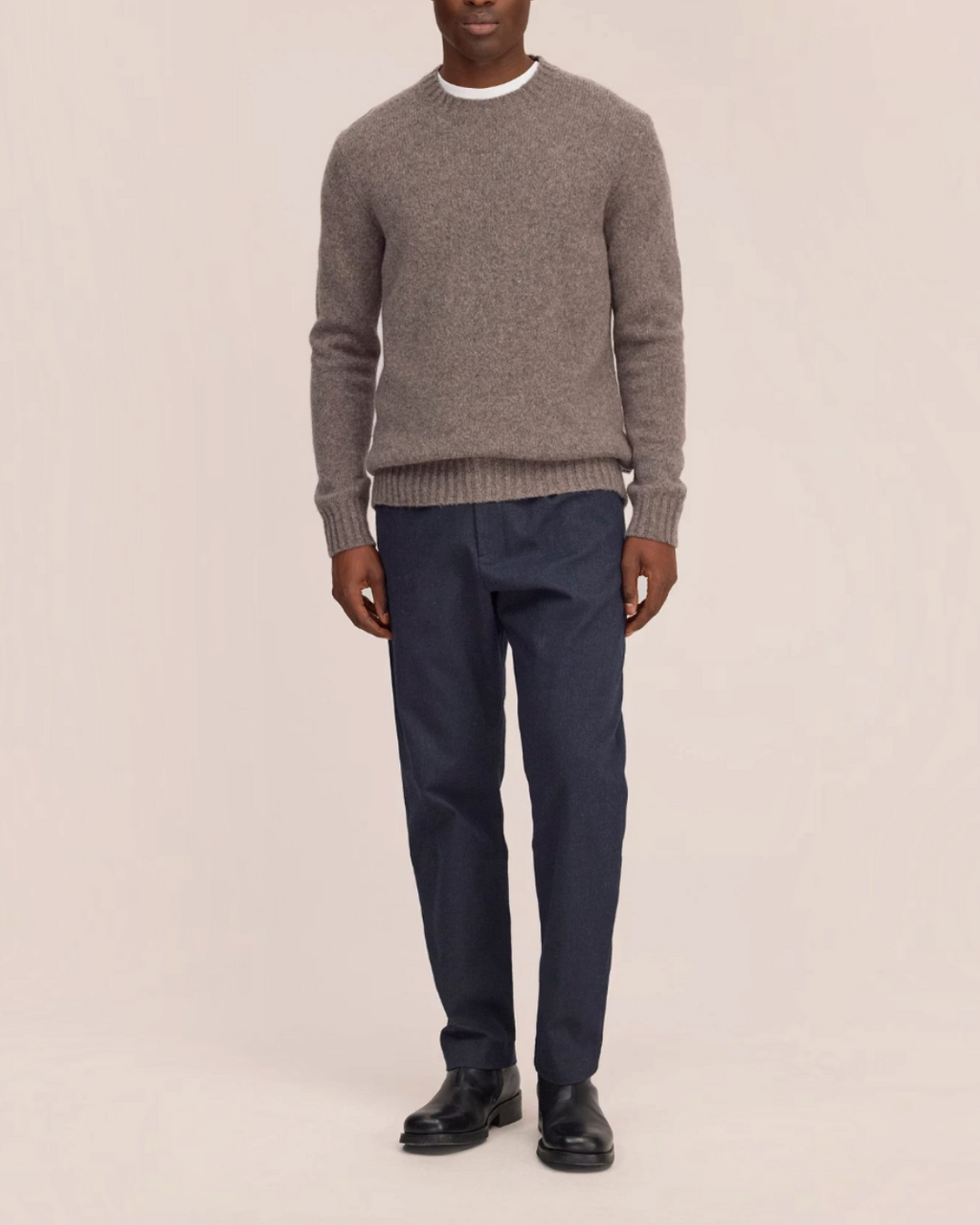 Homme portant le pantalon Bill bleu marine de Merci Paris, coupe décontractée en sergé chiné avec jambes fuselées.