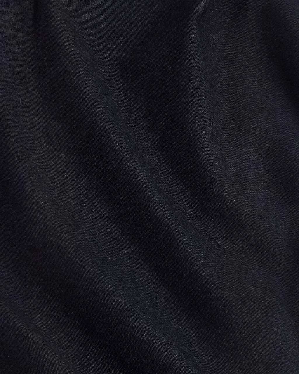 Gros plan sur le tissu sergé chiné bleu marine du pantalon Bill de Merci Paris, texture douce et légèrement brossée