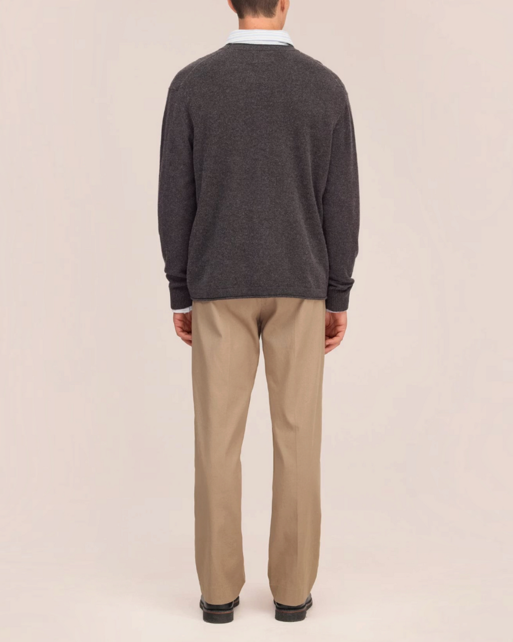 Vue arrière d'un homme portant le pull en laine gris NN.07 de Merci Paris avec un pantalon beige