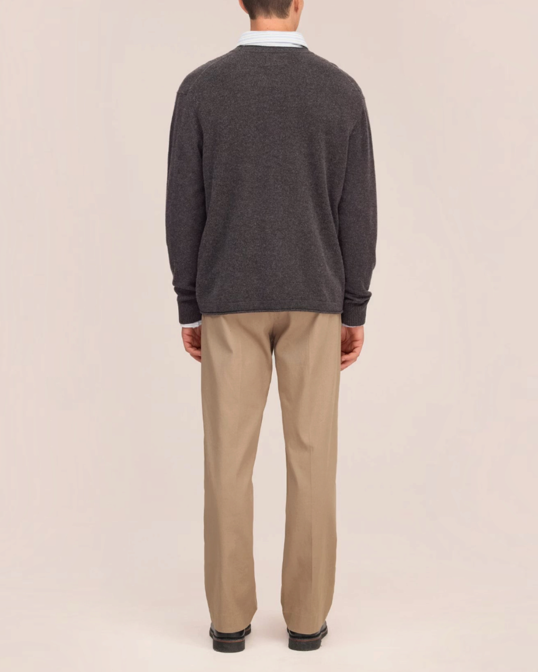 Vue arrière d'un homme portant le pull en laine gris NN.07 de Merci Paris avec un pantalon beige