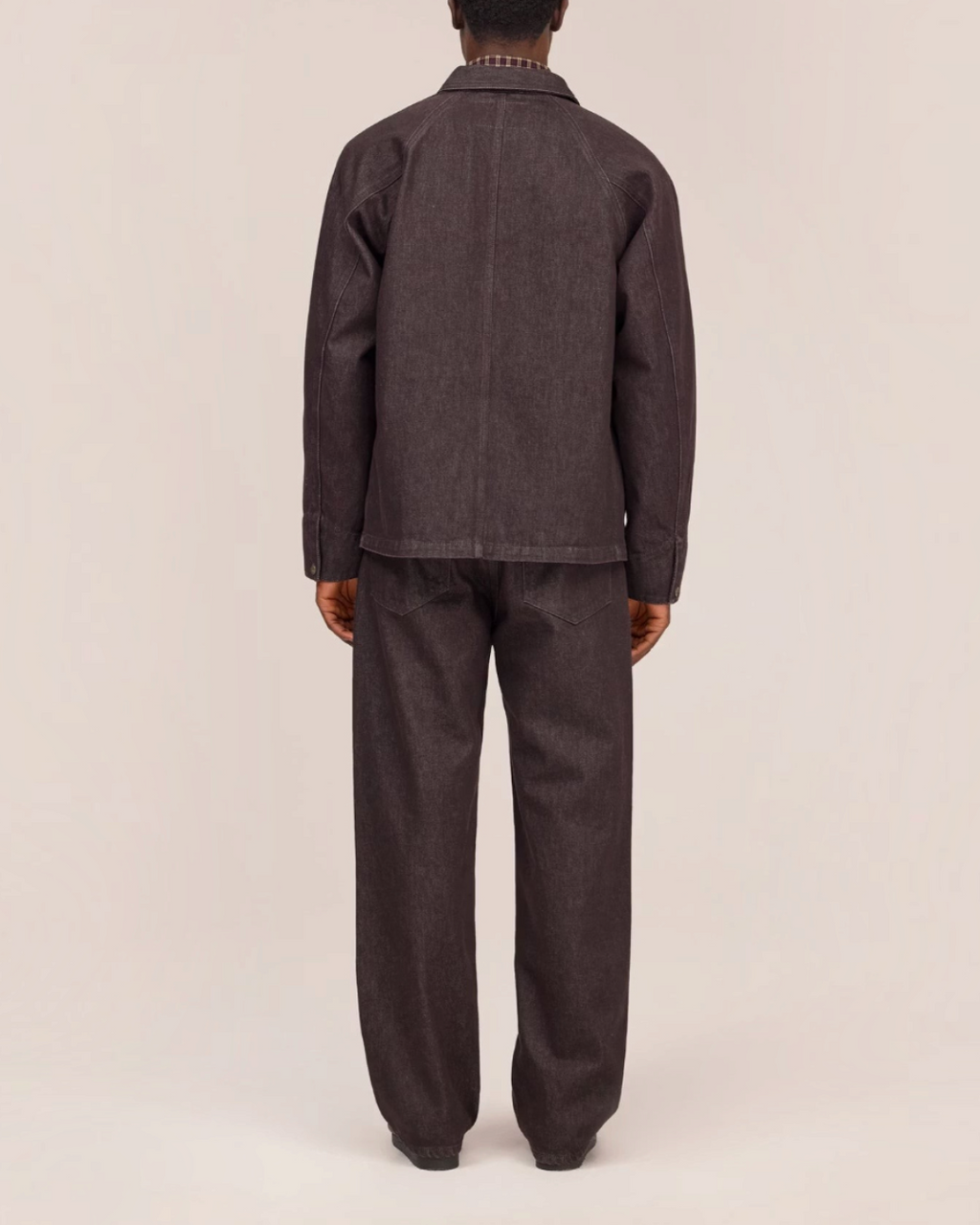 Vue arrière d'un homme portant la veste Aiko marron en denim épais de Merci Paris avec des manches raglan.