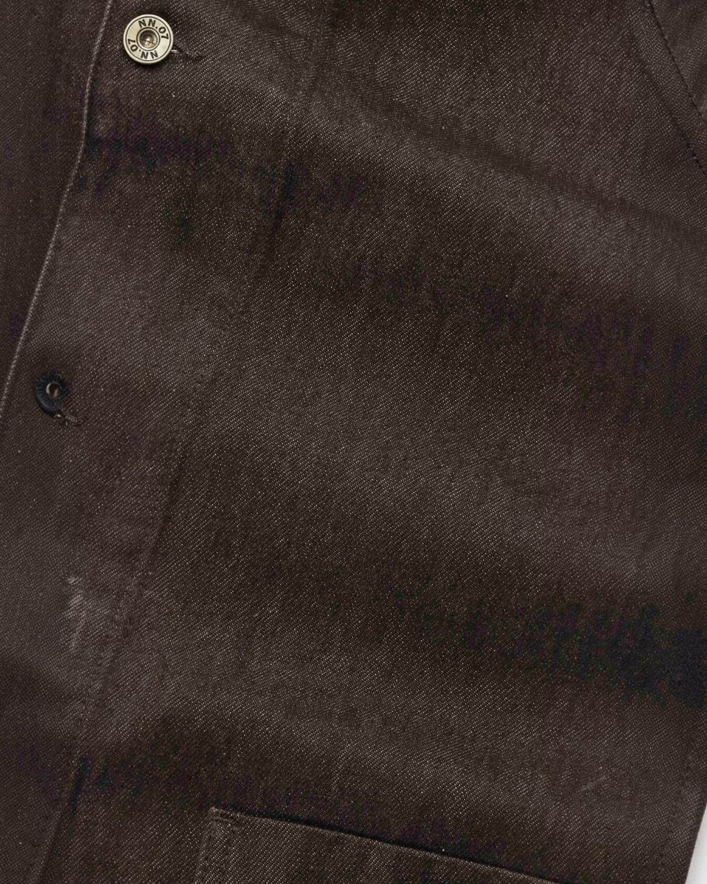 Gros plan sur la veste Aiko marron en denim de coton épais de Merci Paris, avec bouton en laiton vieilli siglé NN.07