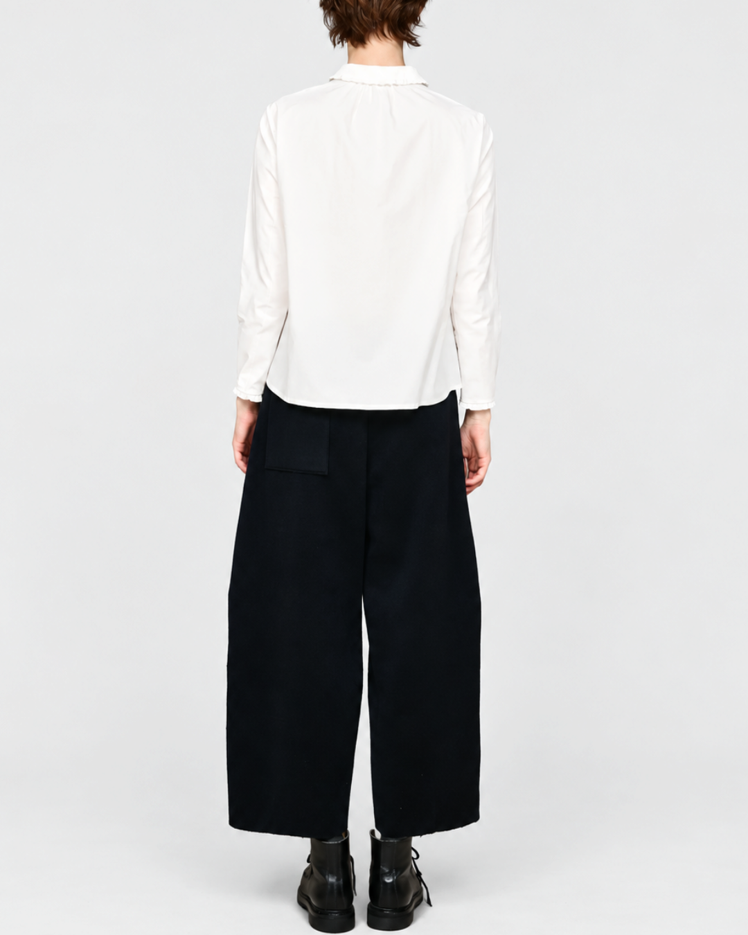 Vue arrière de la chemise blanche ELEPH Happy en coton avec col volanté, portée par une femme sur fond neutre