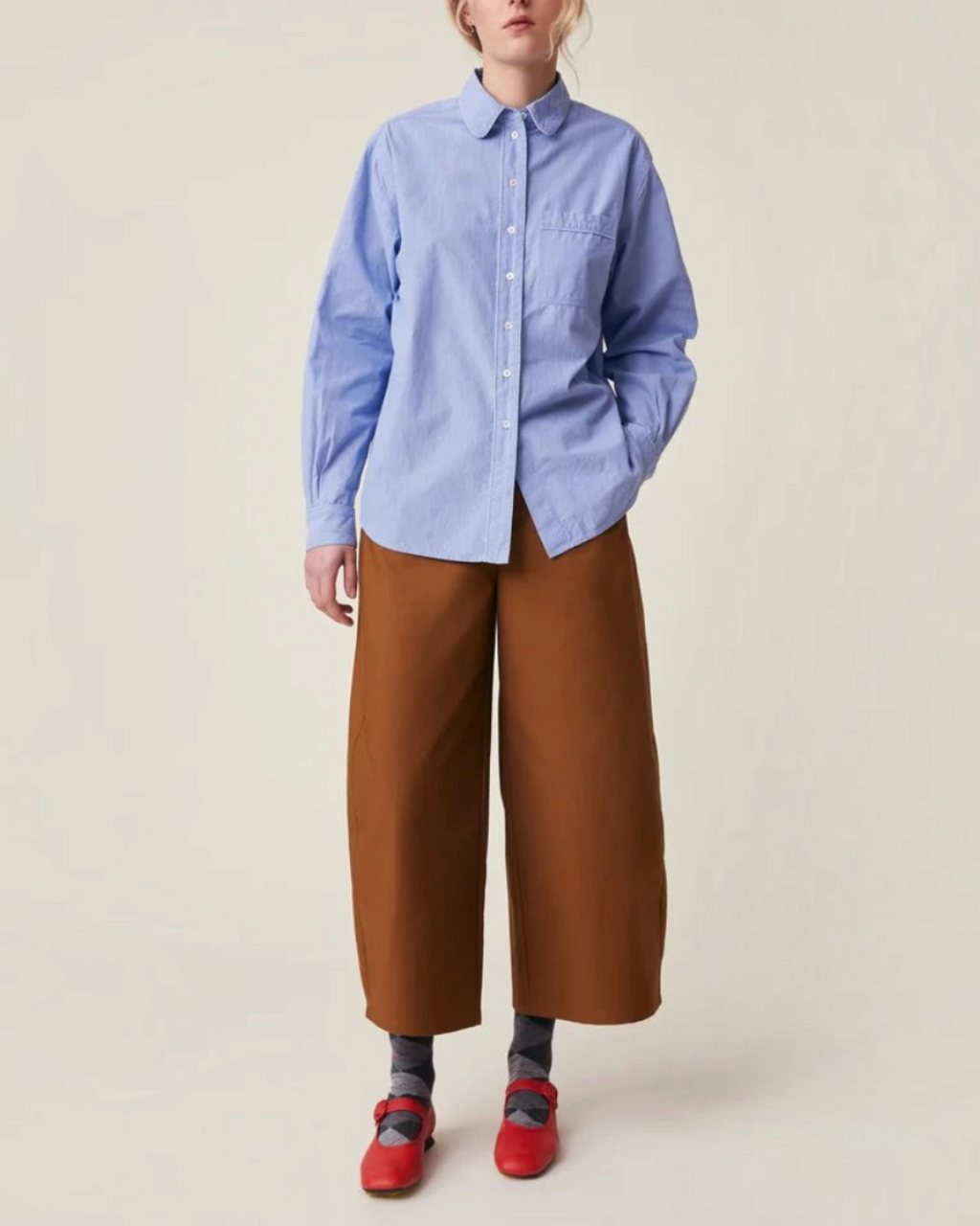 Modèle portant la chemise Henriette en coton bleu de Merci Paris avec col rond, poche poitrine et boutons