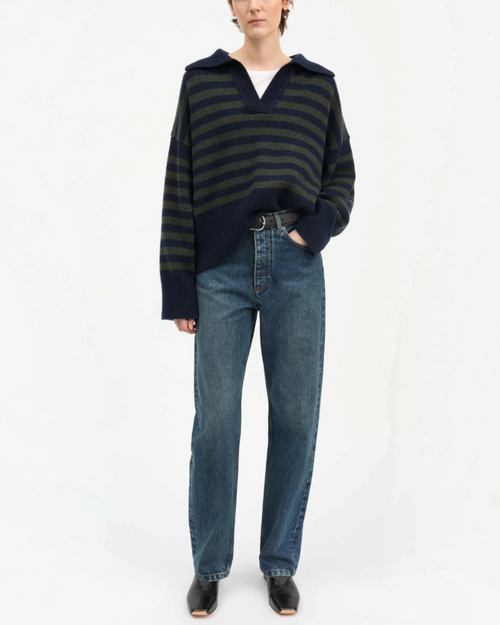 Sweater Skall Studio in navy and green striped merino wool with V-neck worn by a woman with jeans bleu