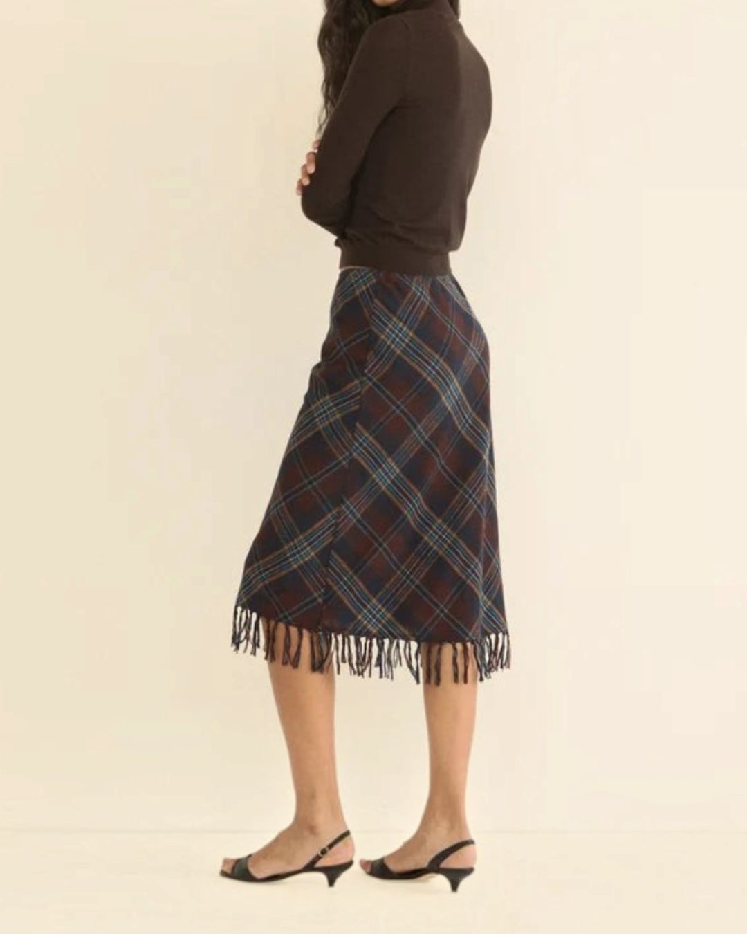 Model wearing Merci Paris Dôen Elowette midi skirt in brown checked wool with fringed hem