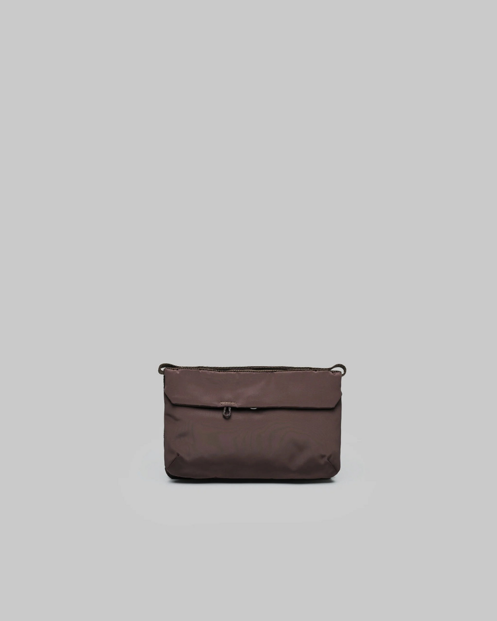 Sacoche de téléphone marron Topologie compacte avec poches zippées, disponible chez Merci Paris