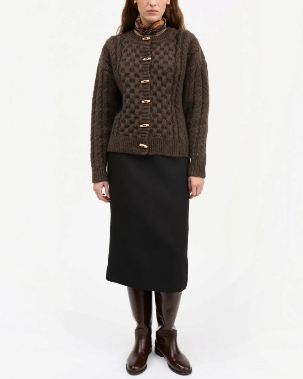 Modèle portant le cardigan Lennox marron foncé en laine torsadée de Merci Paris avec des boutons en bois