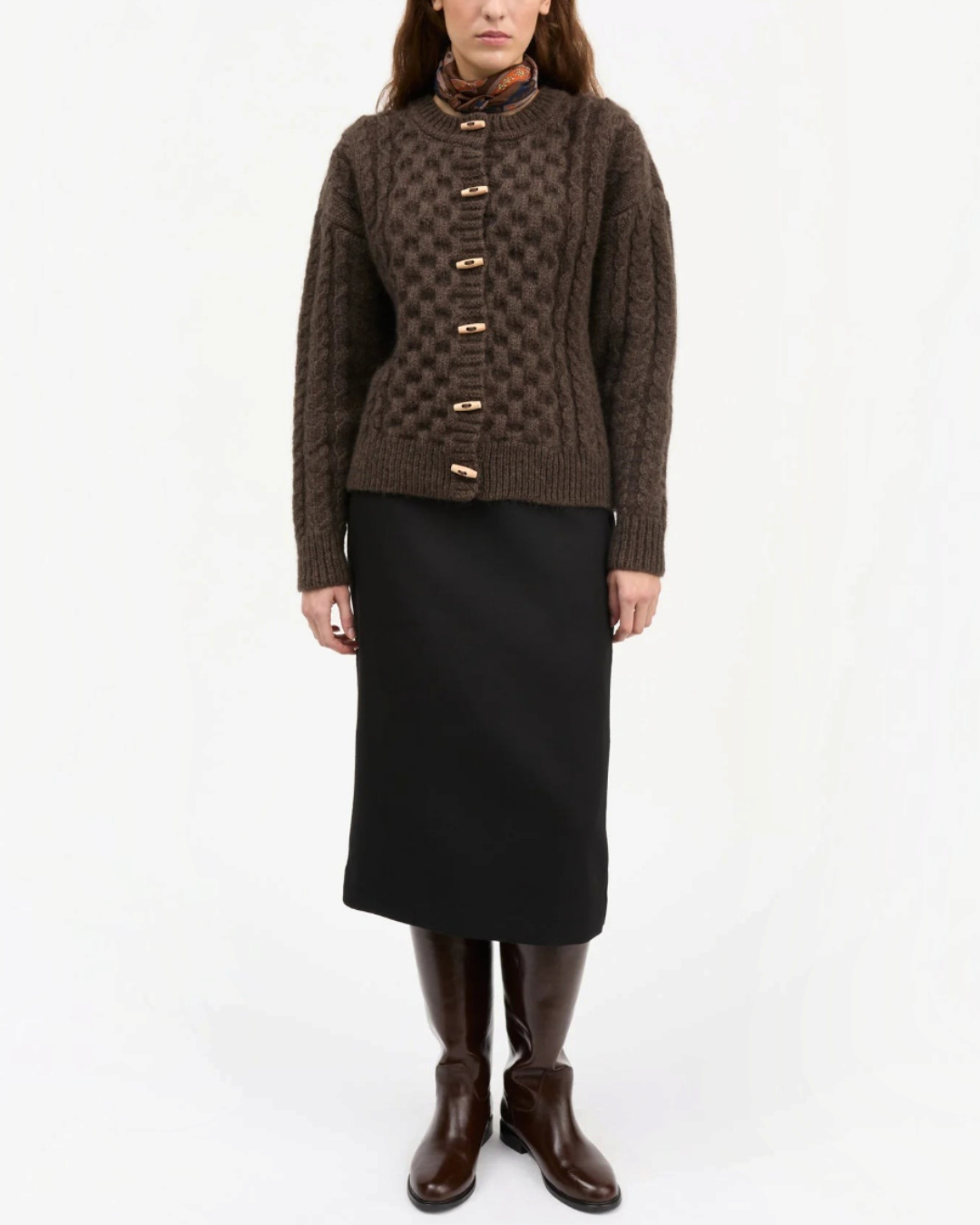Modèle portant le cardigan Lennox marron foncé en laine torsadée de Merci Paris avec des boutons en bois