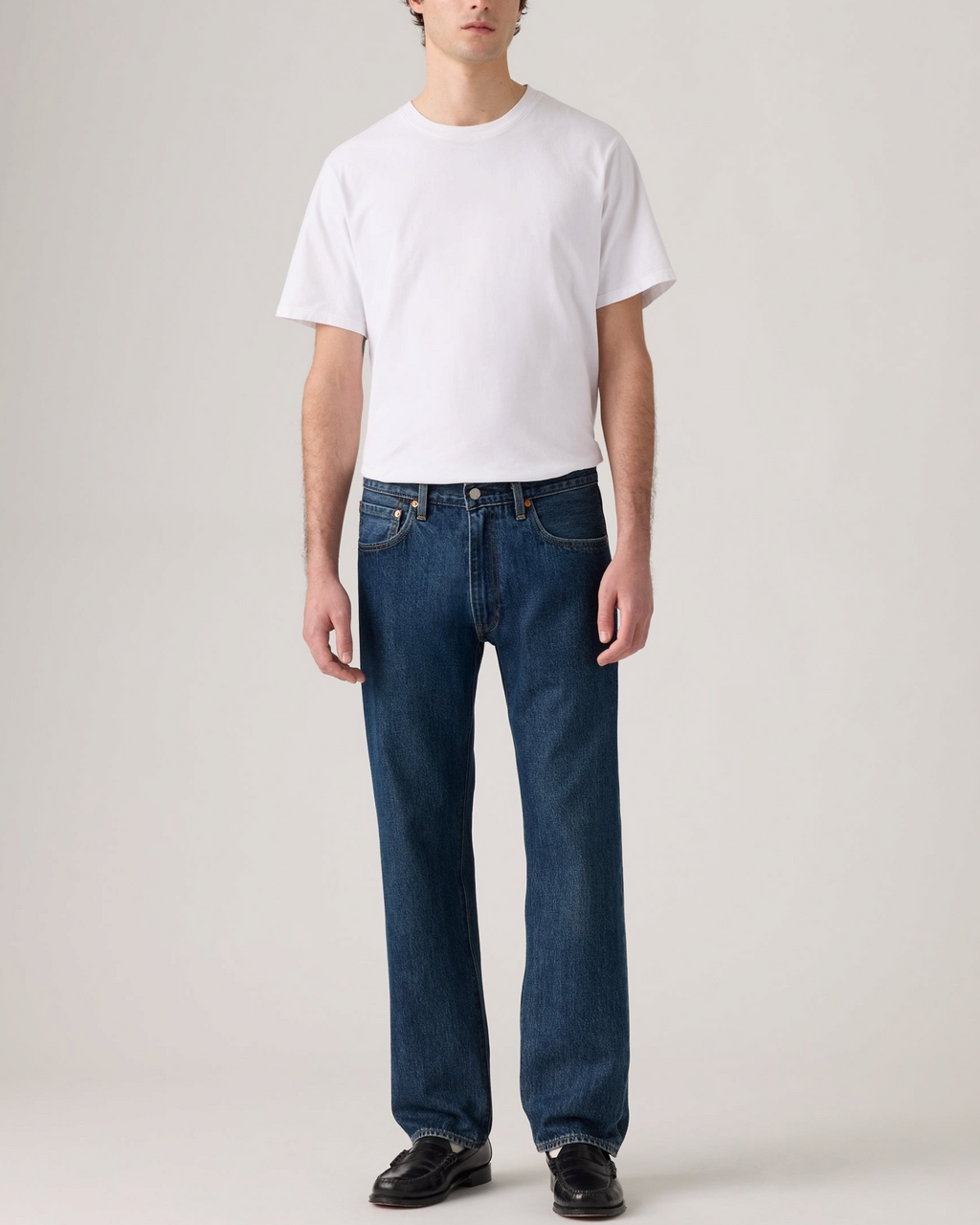 Homme portant un jean Levi's 555 Relaxed Straight bleu indigo en coton rigide, vendu par Merci Paris
