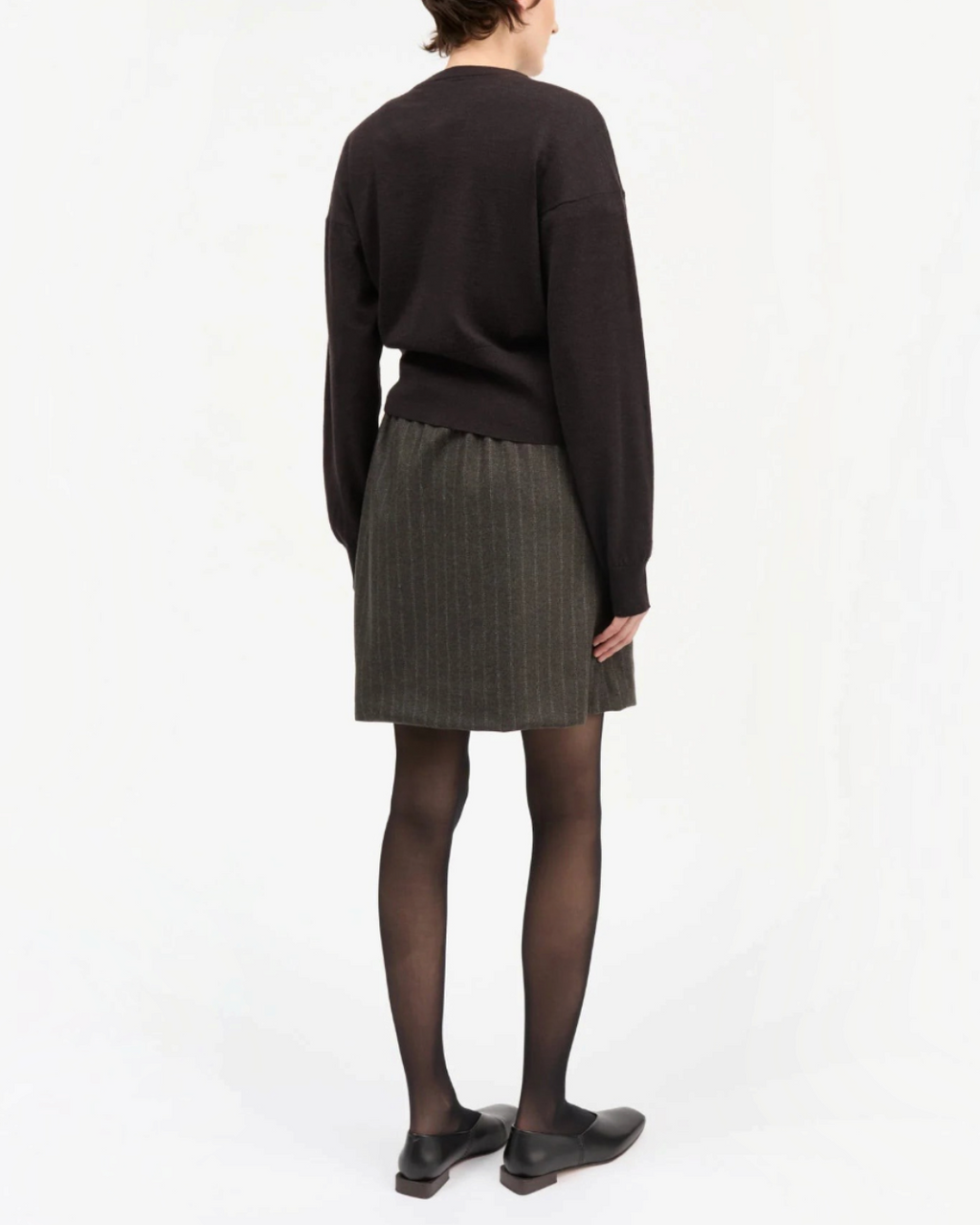 Vue arrière d'une jupe courte Skall Studio en laine recyclée marron et noire à rayures fines portée par un mannequin