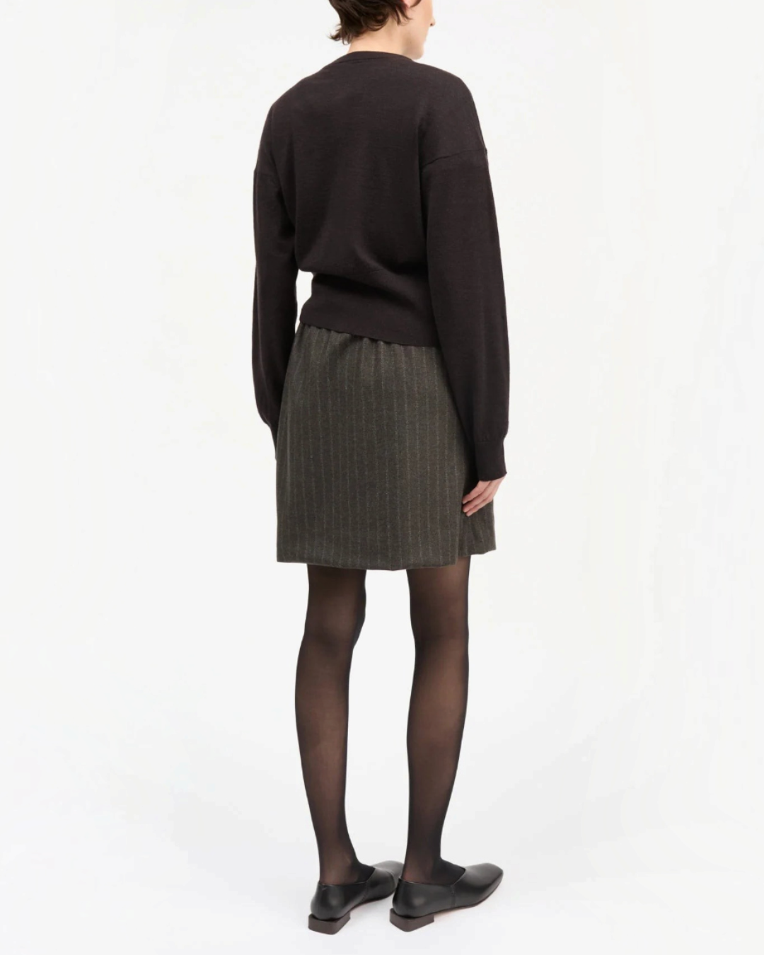 Vue arrière d'une jupe courte Skall Studio en laine recyclée marron et noire à rayures fines portée par un mannequin
