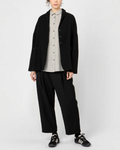 Modèle portant un pantalon 7/8 noir Merci Paris de la marque Apuntob avec une coupe ample et des pinces à la taille