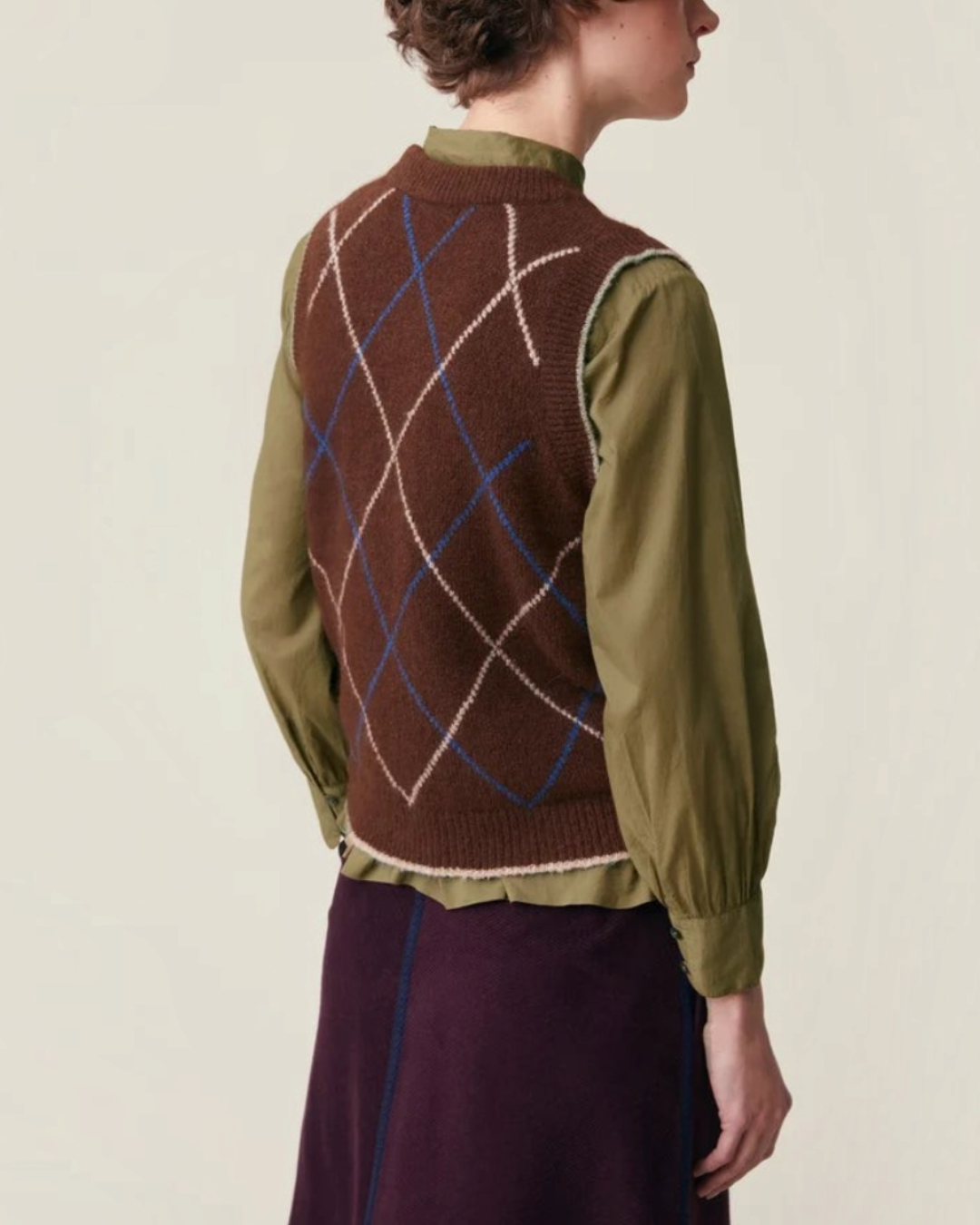 Pull sans manches Merci Paris Moismont Eddy marron à motif losanges colorés porté sur une chemise kaki