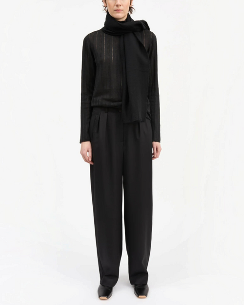 Model wearing black wool Painter pants from Skall Studio at Merci Paris, wide cut and waist semi-high.