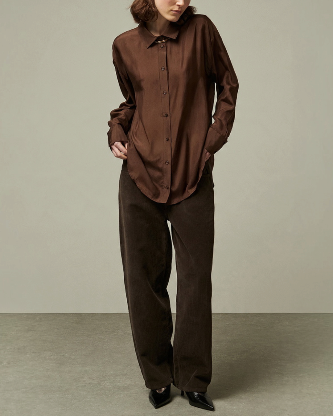 Modèle portant le pantalon Russel en velours côtelé marron de Merci Paris avec une chemise assortie