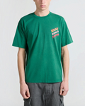 Homme portant un t-shirt Merci Paris Bisous Skateboard vert sapin en coton avec logo poitrine flammes multicolores