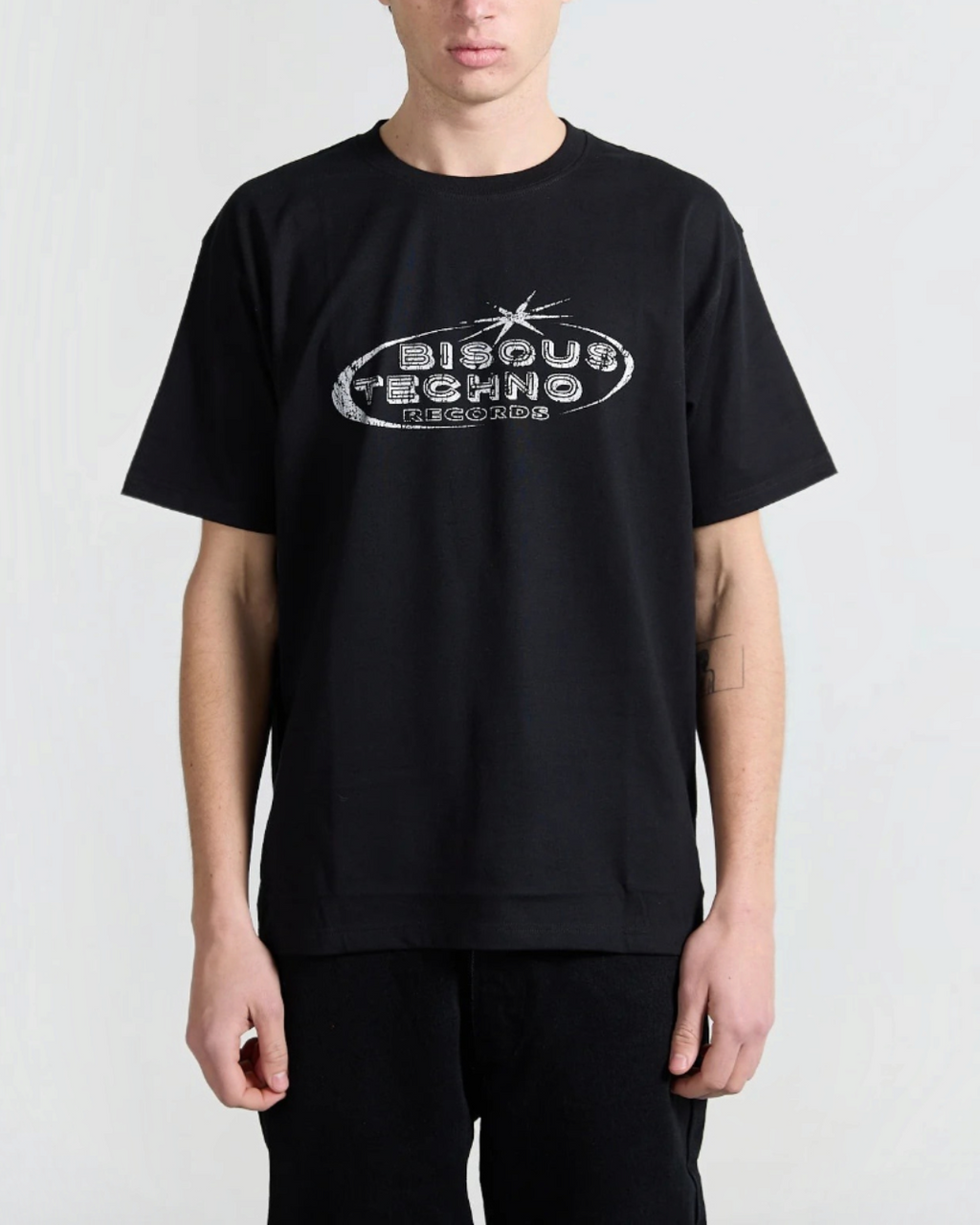 T-shirt noir en coton Merci Paris avec logo Bisous Techno Records blanc sur la poitrine porté par un mannequin