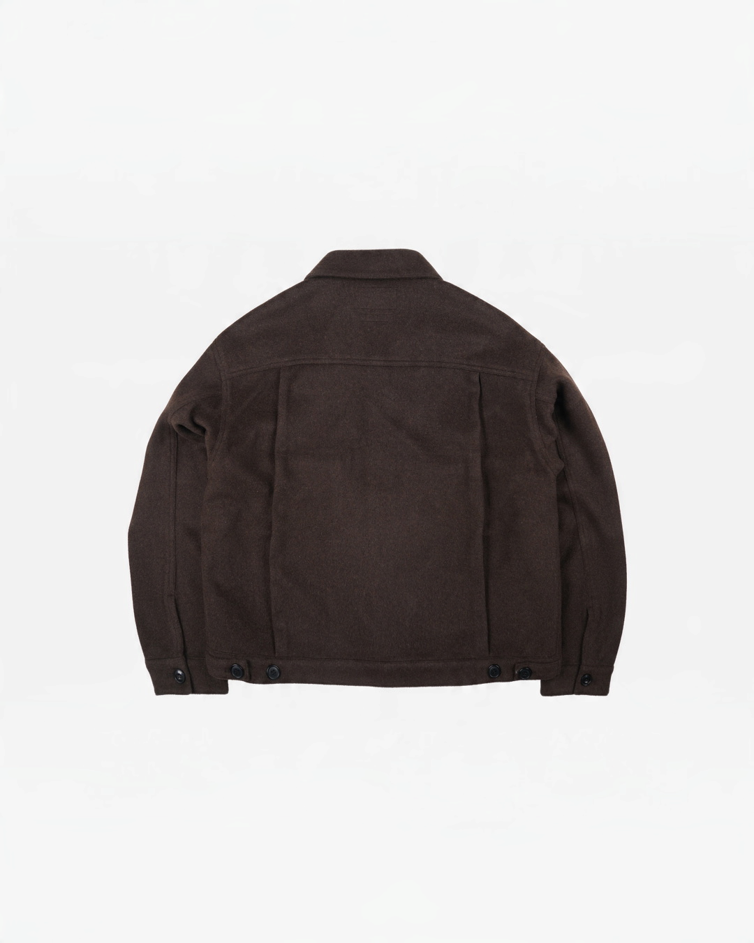 Vue arrière de la veste en laine marron Frizmworks chez Merci Paris avec empiècement plissé et pattes de réglage