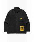 Veste de travail noire Service Works par Merci Paris en toile de coton biologique avec poches et étiquettes jaunes