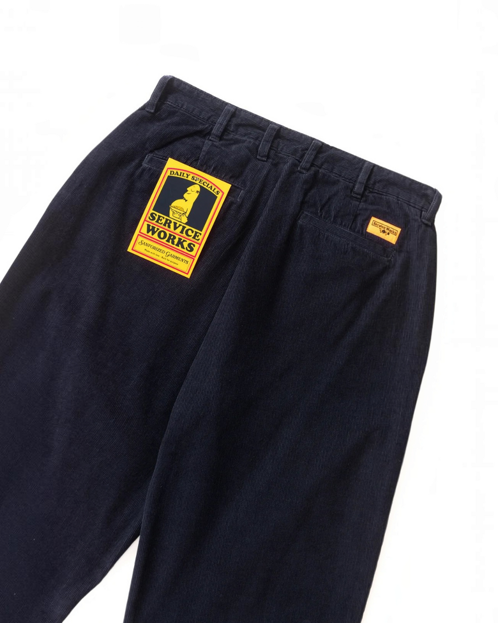 Pantalon en velours bleu Merci Paris Service Works avec étiquette jaune distinctive sur la poche arrière