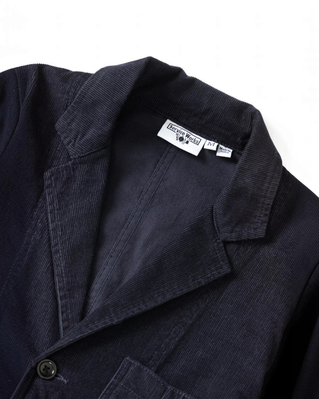 Veste en velours côtelé bleu marine Service Works chez Merci Paris avec col à revers et fermeture à trois boutons