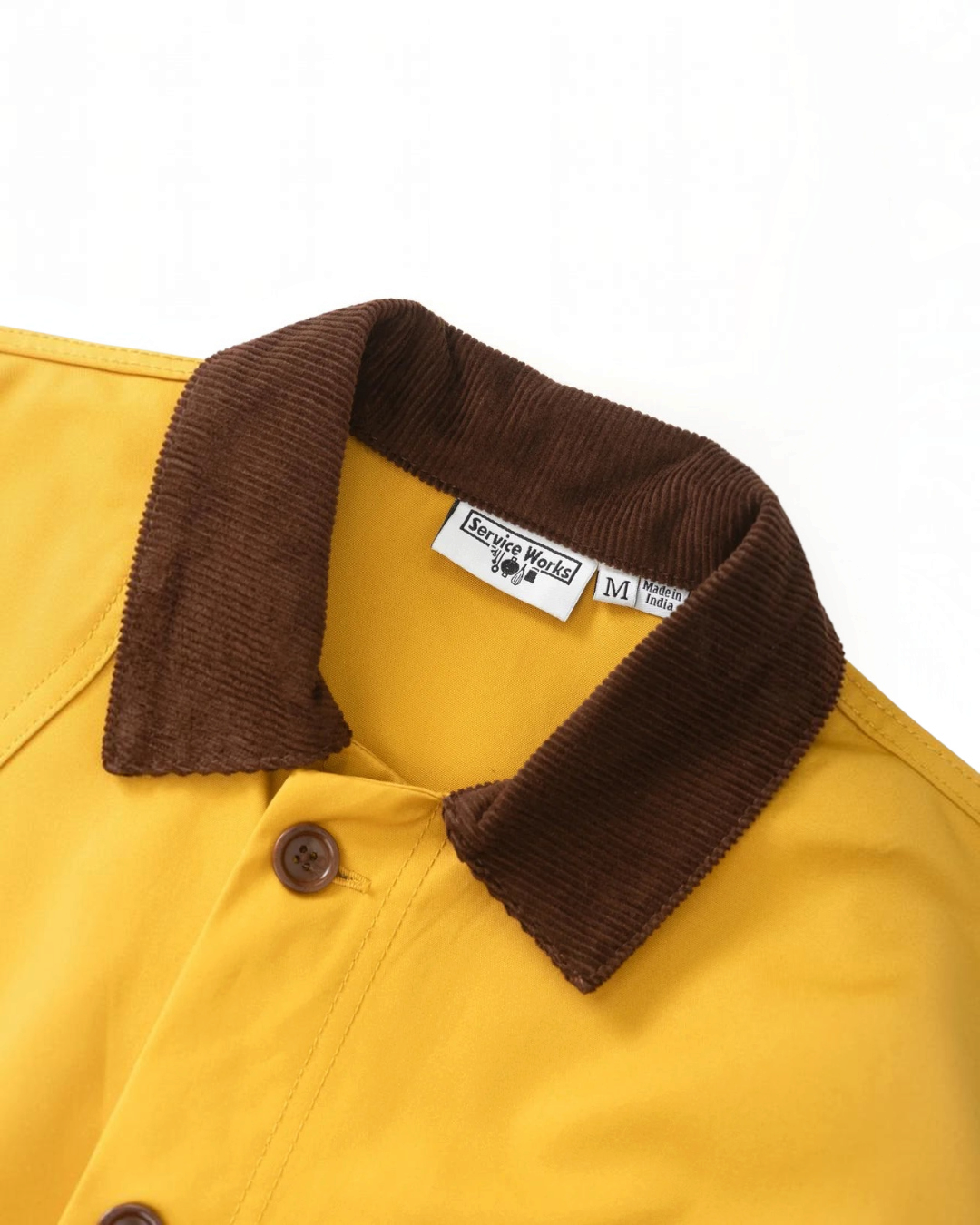 Veste cirée jaune Merci Paris Service Works avec col contrastant en velours côtelé marron et boutons en corozo