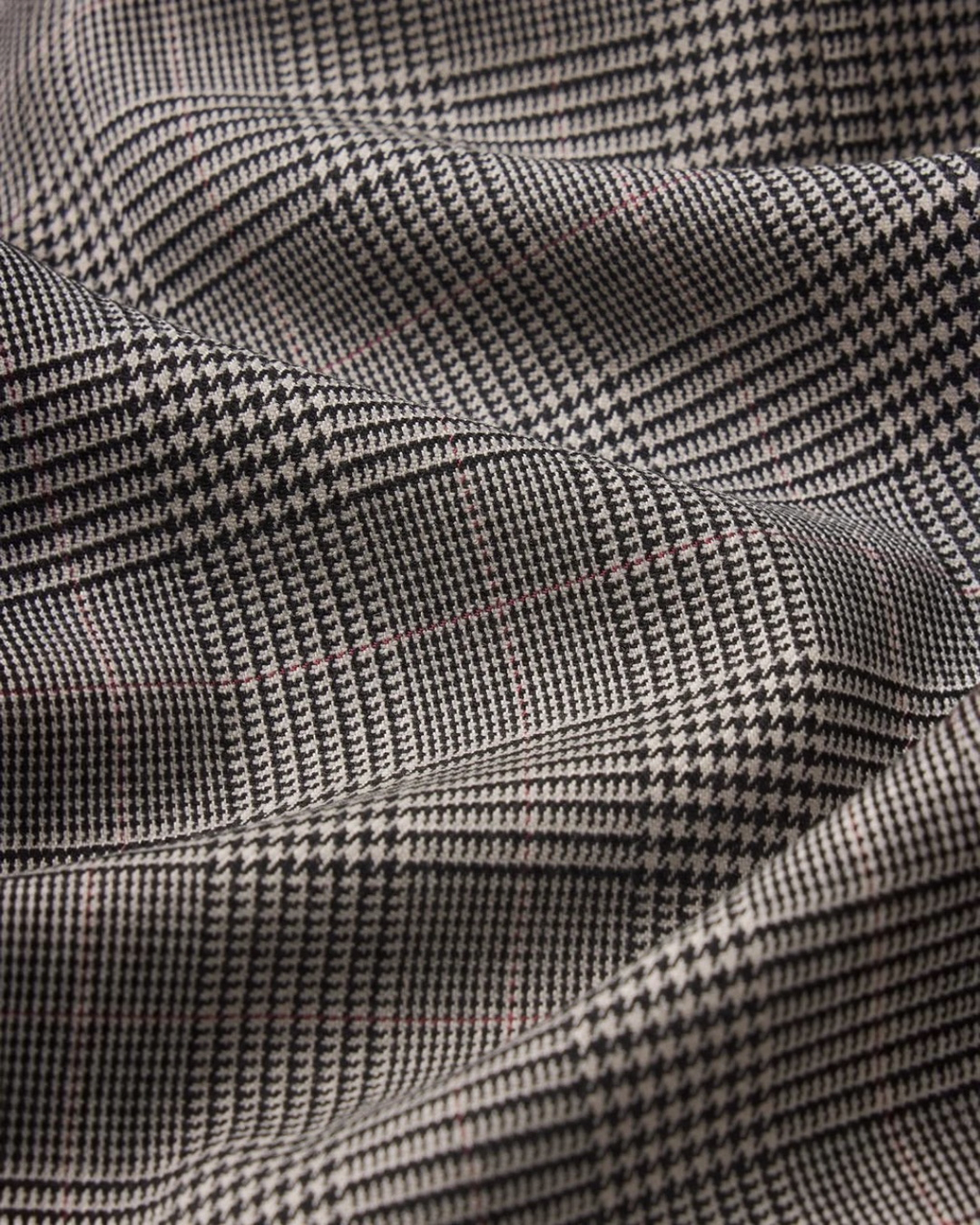 Gros plan sur le tissu en laine mélangée à motif pied-de-poule noir et blanc de la veste Merci Paris Frame
