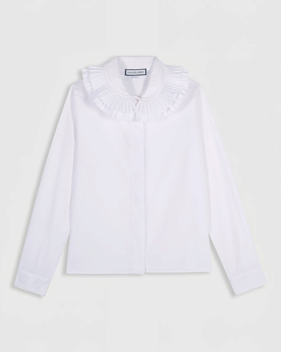 Chemise blanche Maria De La Orden chez Merci Paris avec un double col volanté élégant et une coupe classique