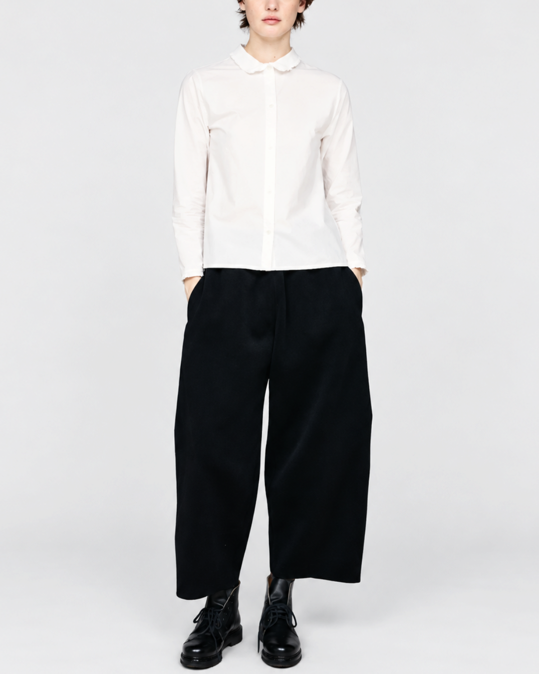 Modèle portant la chemise blanche ELEPH Happy en coton avec col volanté, disponible chez Merci Paris