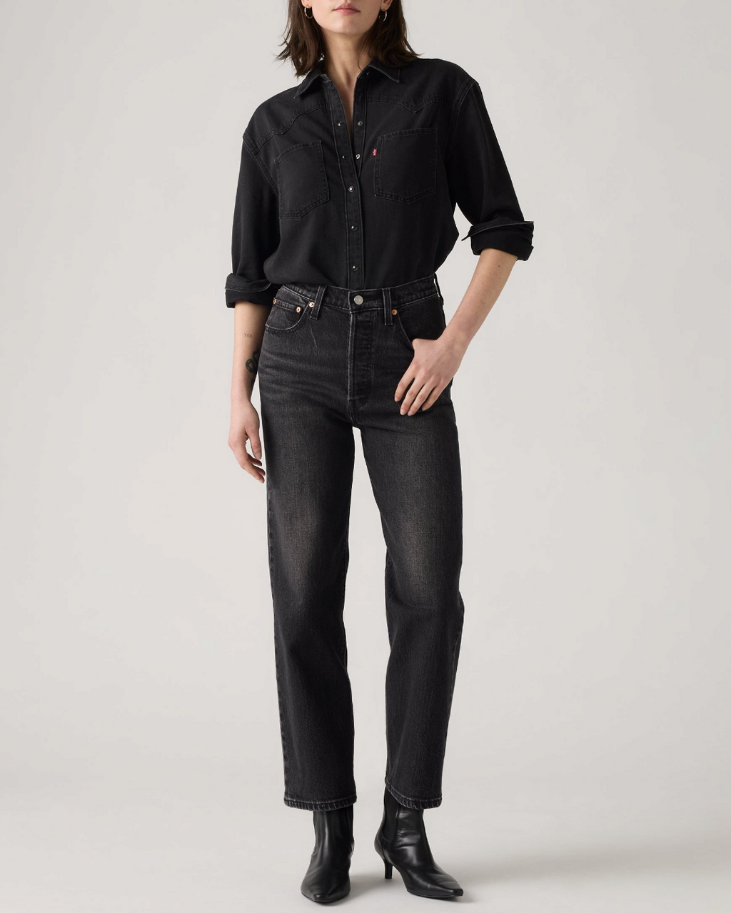 Modèle portant un jean Levi's Ribcage Straight Ankle noir délavé et une chemise assortie chez Merci Paris