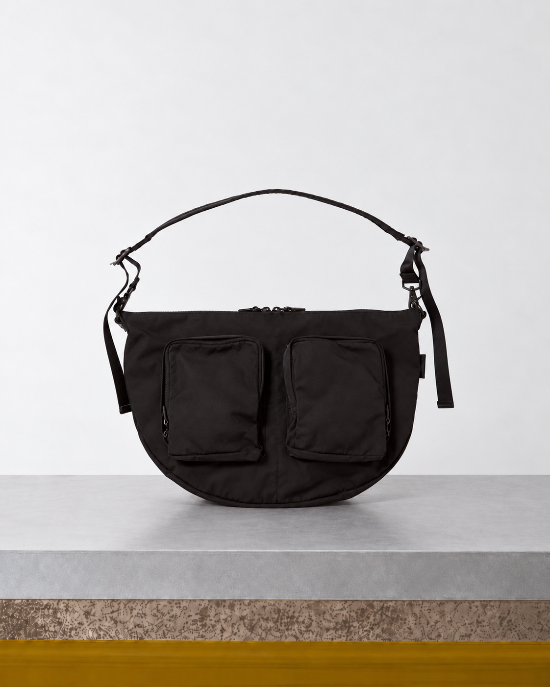 Amiacalva - Sac Gabardine Bodybag - Noir posé sur le banc